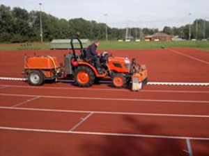 Algenbestrijding op atletiekbaan